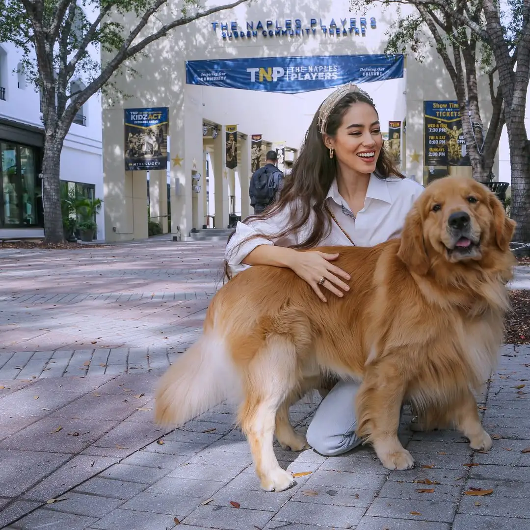 women sitting petting dog